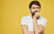 © SHOTPRIME STUDIO - bearded man in white t-shirt yellow background studio emotion problems