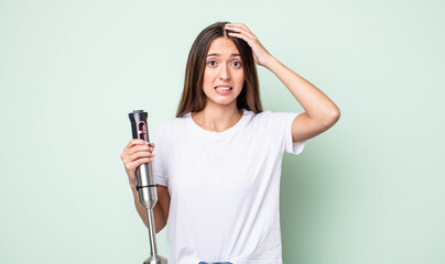 Poster - young pretty woman feeling stressed, anxious or scared, with hands on head. hand mixer concept