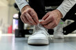 © Jelena Stanojkovic - Cropped shot of an unrecognizable sportsman tying his shoelaces in a gym. Shot of an unrecognizable man tying his shoelaces in the middle of his exercise routine. Close up.