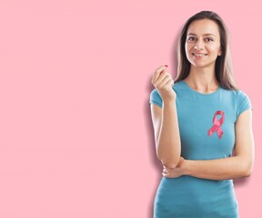 Wall Mural - A woman in T-shirt with a pink satin ribbon symbolizing International Breast Cancer Day,