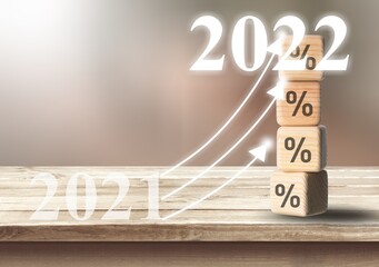 Poster - Shining rise up arrow on wooden blocks chart steps with percentage icons from year 2021 to 2022 on desk,