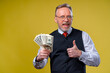 © Vadim - Portrait of happy and white teeth smile senior old business man dressed in white shirt holding money in hands and gesturing isolated on yellow background. Human emotions and money concept