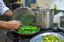Cook Frying Green Pepper On Pan On Stove