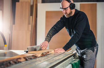 Poster - Carpenter working on woodworking saw machines in carpentry shop, industrial concept