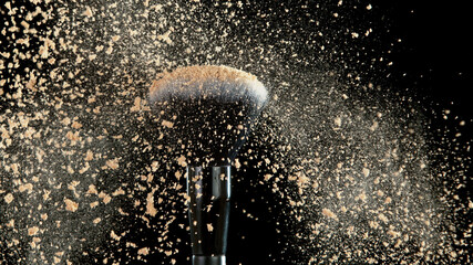 Poster - Soft cosmetics brush releasing a cloud of beige face powder.