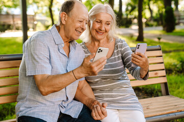 Wall Mural - Happy senior couple with smartphones