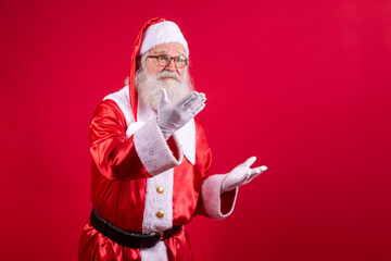 Santa Claus pointing aside, advertising Christmas promotion, New Year Christmas discount advertisement isolated on red background.