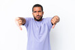 © luismolinero - Young Ecuadorian man isolated on white background showing thumb down with two hands