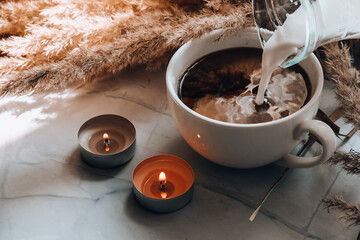 Wall Mural - Pampas grass and add milk in white cup with coffee. Drinking Cappuccino in the breakfast morning at home. Aesthetics