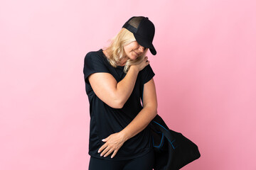 Wall Mural - Middle age woman with sport bag isolated on pink background suffering from pain in shoulder for having made an effort