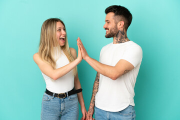 Wall Mural - Young couple over isolated blue background bumping hands