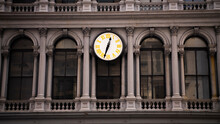A Traditional Analog Clock With Yellow Numbers On The Front Of An Old Office Building In SoHo, Manhattan, New York. 