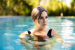 © SuperStock - Portrait or caucasian woman floating in swimming pool in backyard