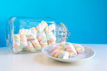 Closeup of rainbow marshmallows in a jar and in a plate