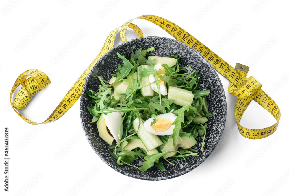 Plate with healthy salad and measuring tape on white background