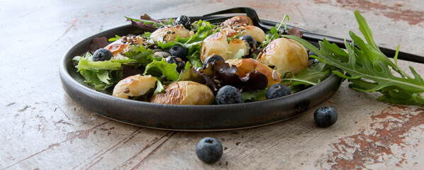 salad plate with baked potatoes and blueberries on the table