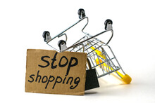 The Concept Of Refusing To Buy Reasonable Consumption Is An Inverted Shopping Cart With A Padlock And A Sign With The Inscription Stop Shopping On A White Background