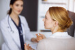 © rogerphoto - Friendly smiling female doctor and patient woman discussing current health examination in sunny clinic. Perfect medical service in hospital. Medicine concept