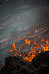 Poster - A mesmerizing vertical shot of an active volcano with lava and smoke