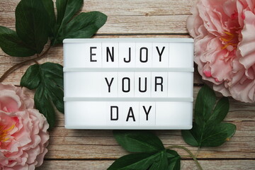Wall Mural - enjoy your day text on lightbox on wooden background