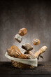 assortment of baked bread falling in straw basket on wooden table