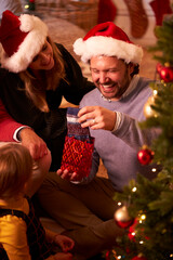 Wall Mural - Father With Present Of Socks As Multi-Generation Family Opening Gifts Around Christmas Tree