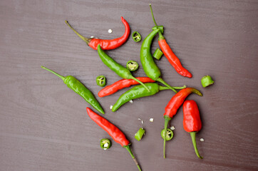 Sticker - Top view of a bunch of red ripe sliced green chili peppers on the brown table