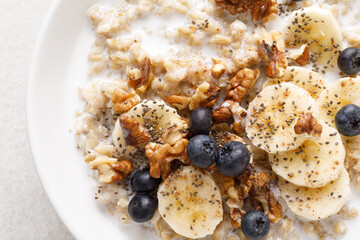 Poster - Oatmeal bowl. Oat porridge with banana, blueberry, walnut, chia seeds and almond milk for healthy breakfast or lunch. Healthy food, diet. Top view.