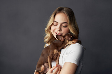 Wall Mural - pretty woman with a small dog makeup posing dark background