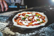 © Mateusz - pizza chef preparing raw dough pizza olive oil basil mozarella fresh italian style napoletana napoli pizza about to be in oven