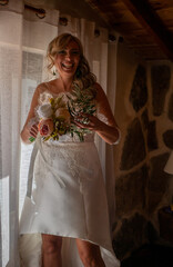 Canvas Print - Spanish bride in a bridal dress holding a bouquet and smiling