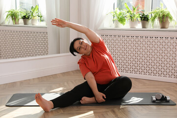 Sticker - Overweight mature woman stretching on floor at home