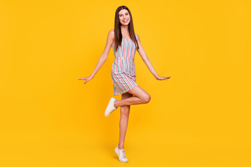 Wall Mural - Full length body size woman smiling careless happy in striped dress isolated vivid yellow color background