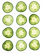 Thin Slices Of Cucumber Shot On A Backlit White Surface