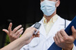 © LIGHTFIELD STUDIOS - cropped view of reporter holding voice recorder near doctor in medical mask gesturing during interview