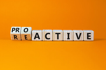 Reactive or proactive symbol. Turned wooden cubes and changed the word reactive to proactive. Business and reactive or proactive concept. Beautiful orange background, copy space.