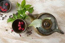 Teapot And Cups Of Herbal Raspberry Tea On A Light Table