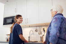 Nurse Helping Elderly Woman At Home