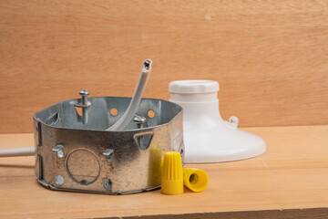 an octagon steel electrical wiring junction box with  wire nuts and a white utility light socket in a construction environment