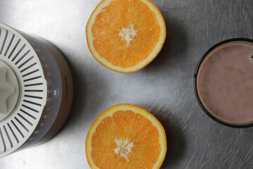 Canvas Print - Top view of oranges near glass and juicer, on a metal surface