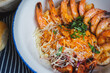 © Evgenii Starkov - Traditional bright shrimp risotto in a bowl on a table in a restaurant with a beautiful decor in a dark key close-up.