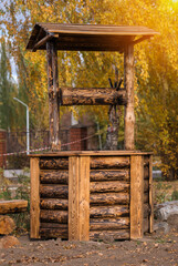 Wall Mural - A wooden well made of burnt logs as a design element of a public park