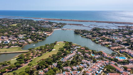 Wall Mural - Aerial overview of luxury villas located around Quinta do Lago, Algarve, Portugal, Europe. Drone shot in the green zone.