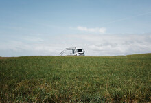 Camper Van Alone In A Large Green Open Field In England