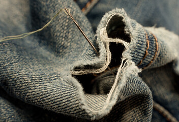 Canvas Print - Hole in jeans. Needle with thread for darning jeans. Tools for work dressmaker, seamstress fashion designer