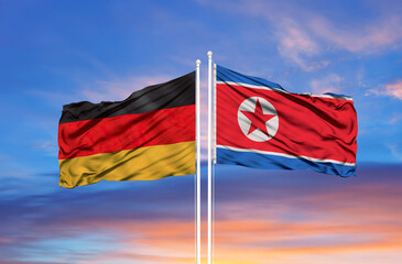 Wall Mural - Germany and North Korea flag waving in the wind against white cloudy blue sky together. Diplomacy concept, international relations