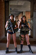 © Roman - Two Military Female Soldiers in Gear Ammunition Posing At Camera With Weapons Guns. Sexual Members Of Military Forces Ready To Strike, Country Defense On Battle Fight Area, In Building