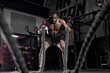 © Roman - Athletic active african man with battle rope doing exercise in functional training fitness gym exercising with battle ropes at gym. black shirtless guy working out arms and cardio for cross fit