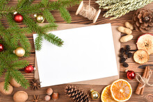 An Envelope And A Blank Sheet Of Paper On A Wooden Tole With Christmas Decorations.