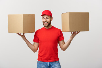 Wall Mural - Portrait delivery man in cap with red t-shirt working as courier or dealer holding two empty cardboard boxes. Receiving package. Copy space for advertisement